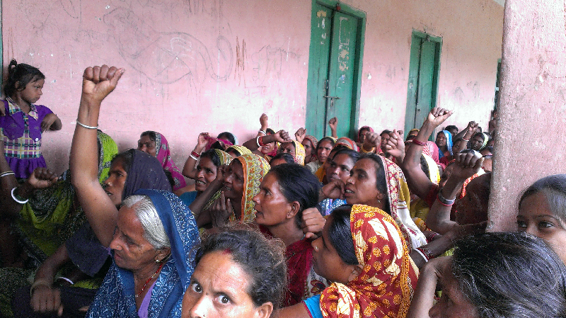 Women raising slogans in a Village Meeting